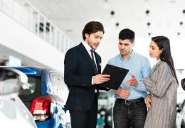spouses-buying-car-consulting-with-dealer-guy-DX7FNUF.jpg